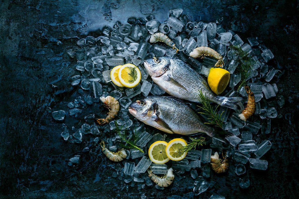 Ganze Fische auf Eis und mit Zitrone umd Crevetten garniert