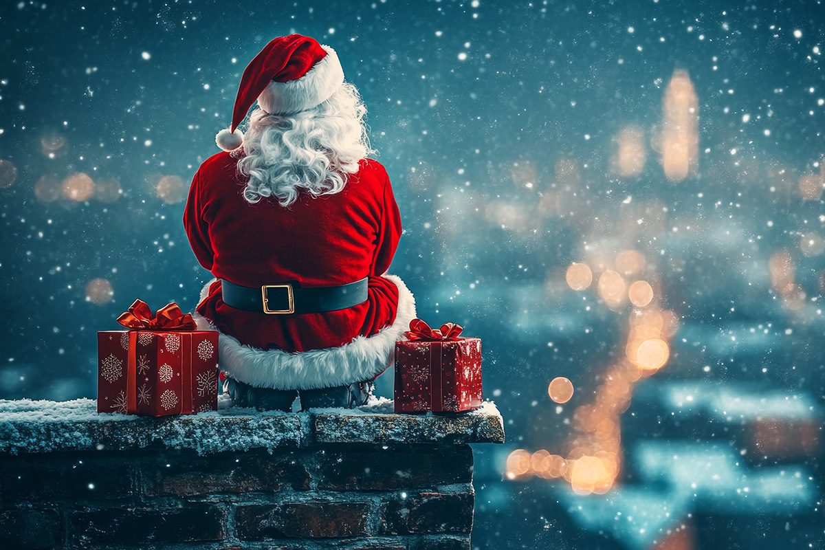 Ein Weihnachtsmann sitzt in einer Winternacht auf einem Schornstein, daneben stehen Geschenke