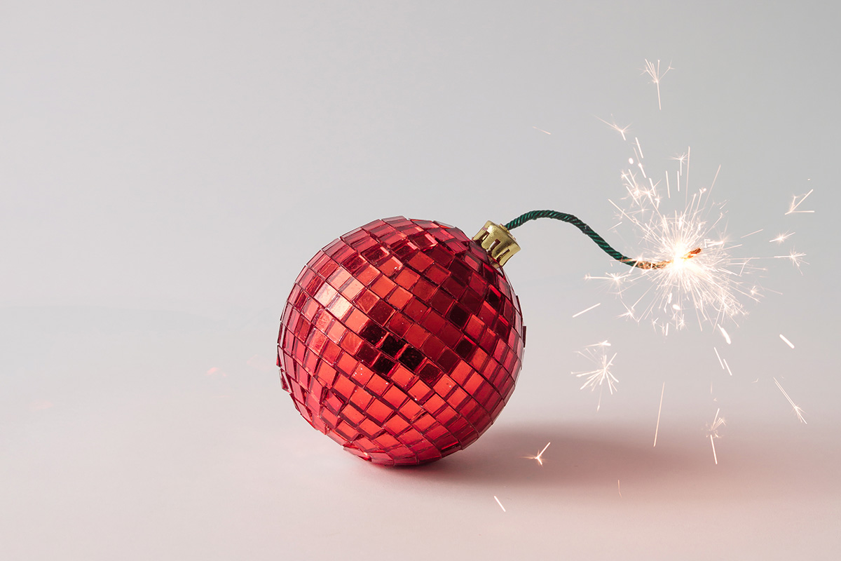 Eine rote Weihnachtskugel mit brennender Zuendschnur
